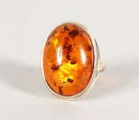 A SILVER AND AMBER RING.