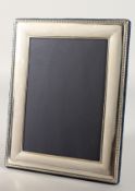 A PLAIN UPRIGHT PHOTOGRAPH FRAME with beaded border. 8.5ins x 6ins.
