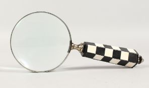 A MAGNIFYING GLASS with chequered handle.