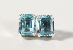 A PAIR OF SILVER EMERALD CUT BLUE TOPAZ EARRINGS.
