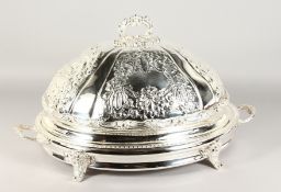 A GOOD LARGE TWO-HANDLED SERVING DISH AND COVER, repousse with scrolls and flowers, the base with