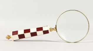 A MAGNIFYING GLASS with chequered handle.