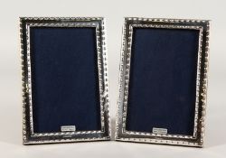 A PAIR OF SILVER PHOTOGRAPH FRAMES with bead edge. 7ins x 5ins.