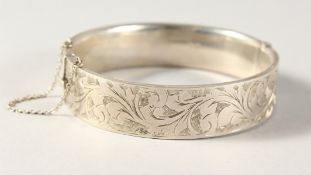 AN ENGRAVED SILVER BANGLE.