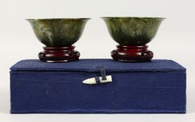 A PAIR OF SPINACH JADE CIRCULAR BOWLS. 4ins diameter, in a blue box.