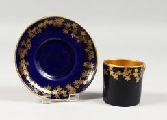 AN EARLY 20TH CENTURY CROWN DEVON BLUE AND GILT COFFEE CAN AND SAUCER.