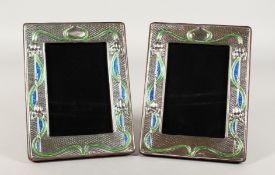 A PAIR OF SILVER AND COLOURED ENAMEL PHOTOGRAPH FRAMES, Art Nouveau design. 7.5ins x 5.75ins.