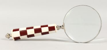 A MAGNIFYING GLASS with chequered handle.