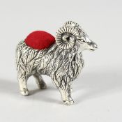 A CAST SILVER RAM PIN CUSHION.