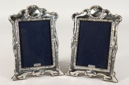 A PAIR OF SILVER PHOTOGRAPH FRAMES with butterflies and flowers. 8ins x 6ins.