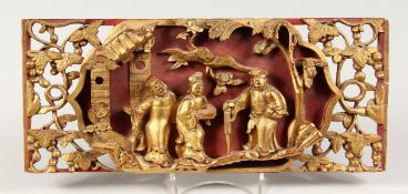 A CHINESE CARVED AND GILDED WOOD PLAQUE with figures and trees. 14ins long.