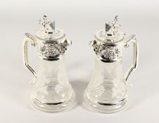 A GOOD PAIR OF GLASS AND SILVER PLATE CLARET JUGS, engraved with fruiting vines. 11ins high.