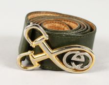 A GUCCI GREEN LEATHER BELT with gilt stirrups and GUCCI logo.
