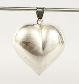 A LARGE SILVER HEART SHAPED PENDANT.