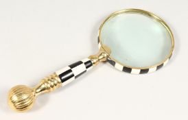 A MAGNIFYING GLASS with chequered handle.