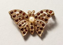 A 9CT GOLD GARNET SET BUTTERFLY BROOCH.