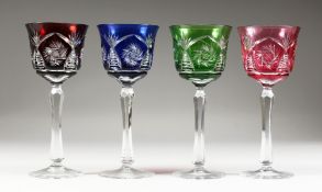 FOUR HARLEQUIN COLOURED CUT CRYSTAL HOCK GLASSES.