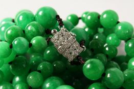 A GOOD SET OF JADE BEADS with white gold and diamond clasp.