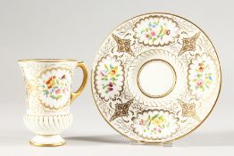 A COALPORT CUP AND SAUCER painted with panels of flowers.