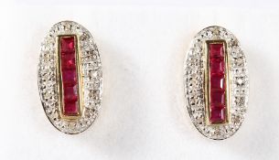 A PAIR OF 9K GOLD CALIBRE CUT RUBIES AND DECO STYLE EARRINGS.