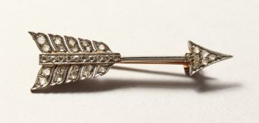 A GOLD AND DIAMOND ARROW BROOCH.