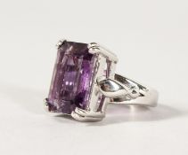 A SILVER LARGE EMERALD CUT AMETHYST RING.