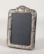 A PHOTOGRAPH FRAME with repousse border. 7ins x 4.5ins.