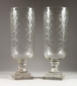 A LARGE PAIR OF CUT GLASS STORM LAMPS on square bases. 16ins high.