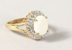 A 9CT GOLD OVAL OPAL AND DIAMOND CLUSTER RING.