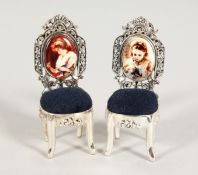 TWO SILVER AND ENAMEL PIN CUSHION CHAIRS.
