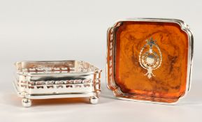 A PAIR OF SQUARE FAUX TORTOISESHELL COASTERS, pierced sides, on four ball feet. 4.5ins.