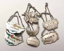 FIVE SILVER WINE LABELS AND TWO ENAMEL.