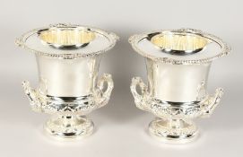 A GOOD PAIR OF SILVER PLATE TWO-HANDLED URN SHAPED WINE COOLERS with liners and rustic mask handles.