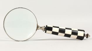 A MAGNIFYING GLASS with chequered handle.