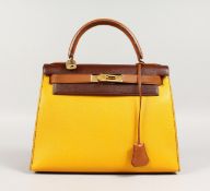 A GOOD HERMES TWO COLOUR LEATHER KELLY BAG, brown and yellow with brass lock. No. 004. 11ins long