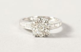 A VERY GOOD 18K WHITE GOLD SEVEN STONE CIRCULAR DIAMOND RING.
