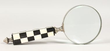 A MAGNIFYING GLASS with chequered handle.