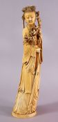 A 19TH CENTURY CHINESE CARVED IVORY FIGURE OF GUANYIN, stood holding a display of flora and a staff,