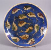 AN ISLAMIC QAJAR BLUE & WHITE POTTERY FISH PLATE, decorated with swimming fish, 25cm