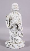 A CHINESE 19TH / 20TH CENTURY BLANC DE CHINE PORCELAIN FIGURE OF ROHAN - in a stood position holding