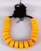 A LARGE 19TH CENTURY ISLAMIC PRESSED AMBER BEAD NECKLACE, with 20 spherical pressed amber beads on a