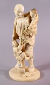 A JAPANESE MEIJI PERIOD CARVED IVORY OKIMONO - MAN AND CHILDREN, the man stood with his two young