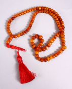 A CHINESE QING DYNASTY CARVED AMBER PRAYER BEADS / ROSARY NECKLACE, comprising 99 beads, 3 spacers