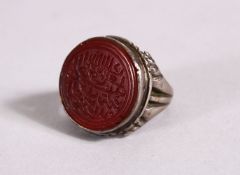 A 19TH CENTURY ISLAMIC INTAGLIO STYLE CALLIGRAPHIC SILVER RING, with an inset hard stone carved with