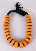 A LARGE ISLAMIC AMBER / BAKELITE CARVED ROUNDEL BEAD NECKLACE with 22 beads each approx, 4cm