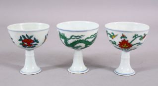 THREE CHINESE DOUCAI & FAMMILE VERTE DECORATED PORCELAIN STEM CUPS, one decorated with dragons,