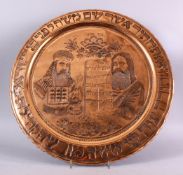 A LARGE EMBOSSED COPPERED JEWISH DISH, with two figures, with script on a board, with borders of