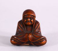 A JAPANESE MEIJI PERIOD CARVED BOXWOOD NETSUKE OF A SEATED ARHAT - in a seated position ,