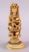 A JAPANESE MEIJI PERIOD CARVED IVORY FIGURE OF A DEITY - KWANNON - in a seated position upon a