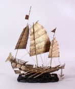 A 19TH CENTURY CHINESE SILVERED MODEL OF A JUNK / SHIP , upon a wave formed carved wooden base, 32cm